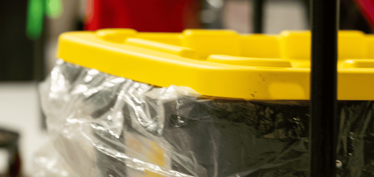 Black storage totes with clear liners and yellow lids
