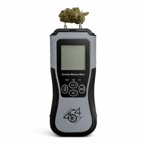 Cannabis moisture meter with prongs inserted into bud to measure moisture content during curing