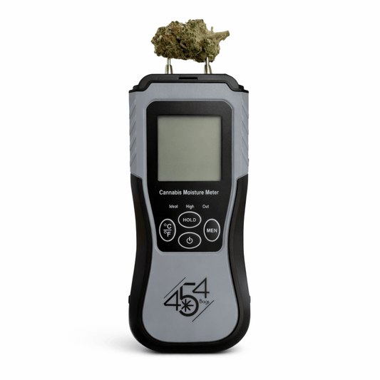 Cannabis moisture meter with prongs inserted into bud to measure moisture content during curing